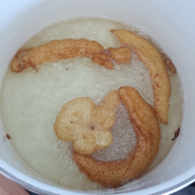 Some weird looking churros curling into the pan