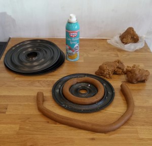 Roll the dough into smooth sausages and place carefully in to the pans. Press the ends together to seal the ring.