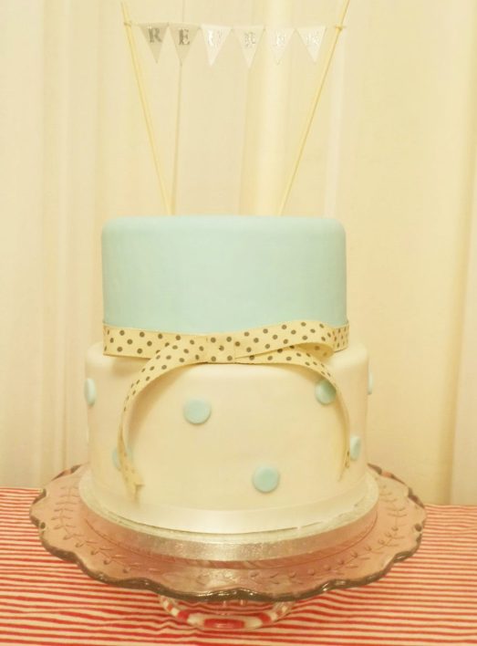 Christening cake. Two tiered iced fruit cake with duck egg blue polka dots and bunting